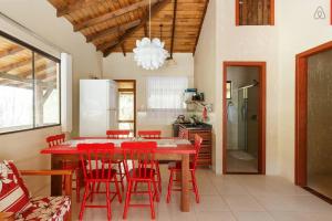 甘博阿Gamboa Luna y Sol Apart-Hotel的厨房配有红色餐桌和红色椅子