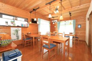 屋久岛尼克伊奇民宿的用餐室配有木桌和椅子