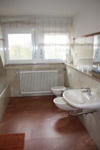 莱茵豪森泰塔湾酒店的浴室设有2个卫生间、水槽和窗户。