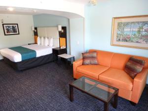 基西米Best Western Plus Orlando Lake Buena Vista South Inn & Suites的酒店客房,配有床和沙发