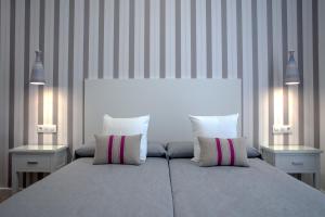 梅里达MPD公寓式酒店的一间卧室配有一张带2个床头柜的大床