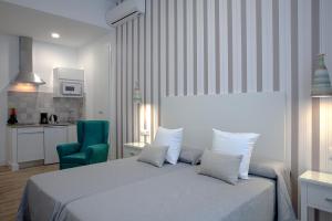 梅里达MPD公寓式酒店的一间卧室配有一张床和一把绿色椅子