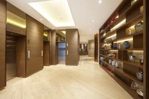 雅加达Ashley Wahid Hasyim Jakarta的走廊设有木镶板,长房间设有架子