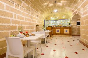 加利波利L'Uomo e il Mare的一间设有白色桌椅的餐厅,拥有砖墙