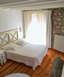 拉波夫拉-德利列特El Castell de la Pobla de Lillet (Adults Only)的一间卧室设有一张床和一个大窗户