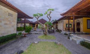 库塔Taman Sari Cottages的一座建筑中间有树的庭院