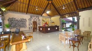 库塔Taman Sari Cottages的餐厅设有木桌、椅子和柜台