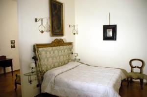 布奇内villa Catola的卧室配有一张床和一张桌子及椅子