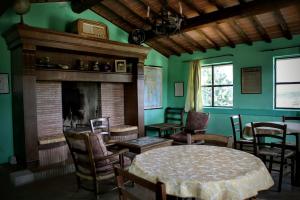 布奇内villa Catola的客厅设有壁炉、桌子和椅子