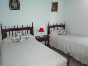 阿尔德亚达维拉德拉里韦拉Casa Rural Mimbrero的一间卧室配有两张床和一张带台灯的桌子