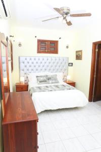 圣多明各Hotel Aluge的卧室配有白色的床和木桌
