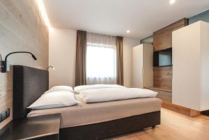 萨伦蒂诺Gasthof Sonne OHG的一间卧室配有带四个枕头的床
