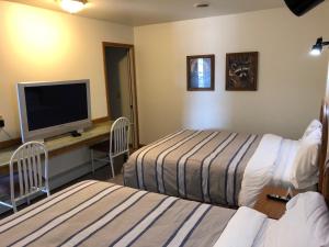 Chatham威力紫汽车旅馆的酒店客房设有两张床和一台平面电视。