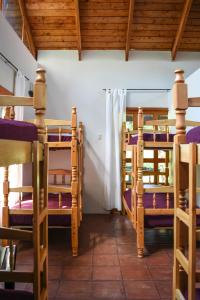 San José PinulaHotel y Resort Quinta del Sol的客房设有三张双层床和木制天花板。