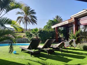 拉普拉亚蒂陶洛Anfi Tauro Rentals的一个带躺椅和游泳池的庭院