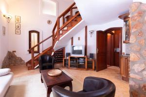 豪伊杜索博斯洛Hajdu Apartman 2.的一间带楼梯和电视的客厅