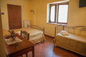 Stella Cilento伊尔维琪奥夫郎托伊奥农家乐的客房设有两张床、一张桌子和一扇窗户。