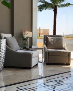 海米斯穆谢特قولدن سكوير طريق الرياض Golden Square Riyadh Road的客厅配有两张沙发和一棵棕榈树