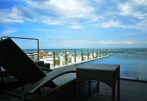 宿务One Central Hotel & Suites的一个带桌椅的海景阳台