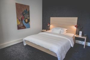 日内瓦蒙里普斯酒店的卧室配有一张白色大床和一幅画