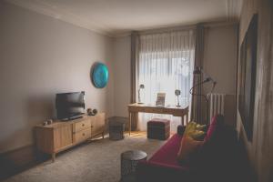 日内瓦蒙里普斯酒店的客厅配有红色沙发和电视