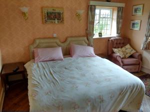 赫克瑟姆Thornley House的一间卧室配有一张大床和一把椅子