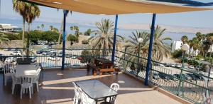 提比里亚Atara Hotel的阳台配有桌椅,享有海景。