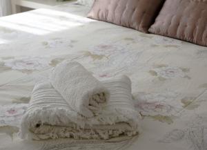 巴罗尼西GiaVa Apartment的铺在鲜花床上的白色毛巾