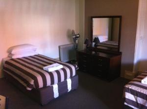阿德莱德大都会酒店的一间卧室配有一张床、梳妆台和镜子