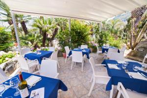 伊斯基亚地中海公园温泉酒店的一间设有蓝色桌子和白色椅子的餐厅