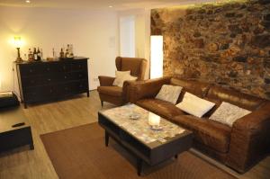 莱米拉斯Pension Schwedenkreuz的客厅设有棕色的沙发和石墙