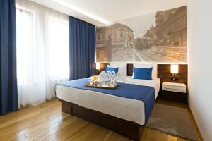 贝尔格莱德阿巴酒店的卧室配有蓝色和白色的大床