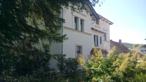 塔勒Villa Heimburg的前面有树木的白色建筑