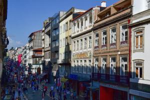 波尔图My Story Apartments Porto - Santa Catarina的一群人沿着街道走着,街道上有许多建筑