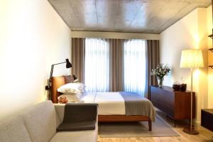 波尔图My Story Apartments Porto - Santa Catarina的酒店客房,配有床和沙发