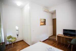 博洛尼亚Le Camere di Porta San Felice - Self Check in的一间卧室配有一张床、一张书桌和一台电视
