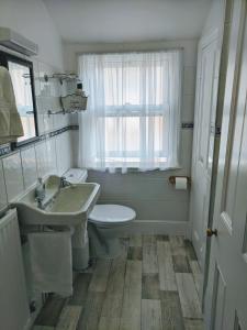 韦尔斯23号酒店的一间带水槽和卫生间的浴室以及窗户。