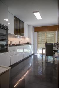 波尔图PortoHouse的厨房配有白色橱柜和桌子