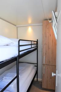 马斯特里赫特Cosy floating boatlodge Athene的客房设有两张双层床和木制橱柜。