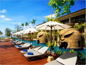蔻立Graceland Khaolak Beach Resort- SHA Extra Plus的游泳池旁的一排躺椅和遮阳伞