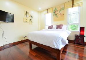 曼谷阿依度假屋的一间卧室配有一张大床和一台平面电视