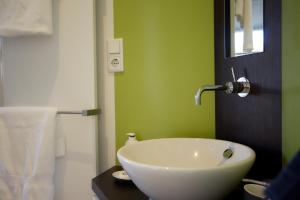 乌得勒支B&B Muntzicht的浴室设有白色水槽和绿色的墙壁