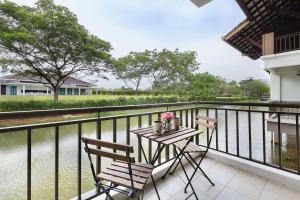 努沙再也Modern Bali Resort by HostaHome, 10mins to Legoland的阳台配有桌椅和水。