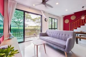 努沙再也Modern Bali Resort by HostaHome, 10mins to Legoland的客厅配有紫色沙发和滑动玻璃门