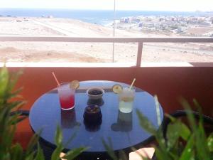 因赫尼奥Burrero Seasight的海滩景阳台的桌子和饮料