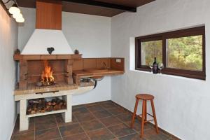 蒂哈拉费Casa Antonia的厨房设有壁炉、凳子和窗户。