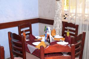 纳库鲁马文酒店的一张带椅子的木桌和一张带瓶子的桌子