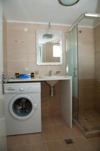 米尔托斯米尔提尼公寓的一间带洗衣机和水槽的浴室
