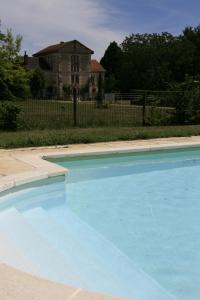 蒙特雷索Gîte du Moulin de Montrésor的一座大蓝色游泳池,位于房子前