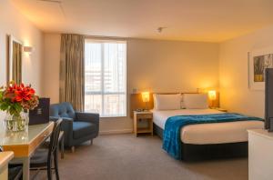 惠灵顿阿斯特里亚公寓酒店的配有一张床、一张书桌和一扇窗户的酒店客房